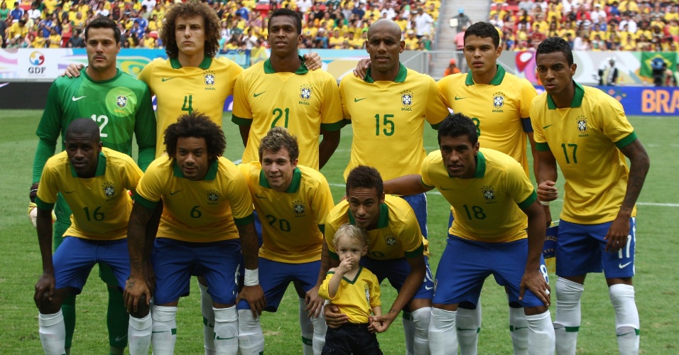 07.set.2013 - Neymar entrou em campo com o seu filho, que até posou para a foto oficial com o time brasileiro