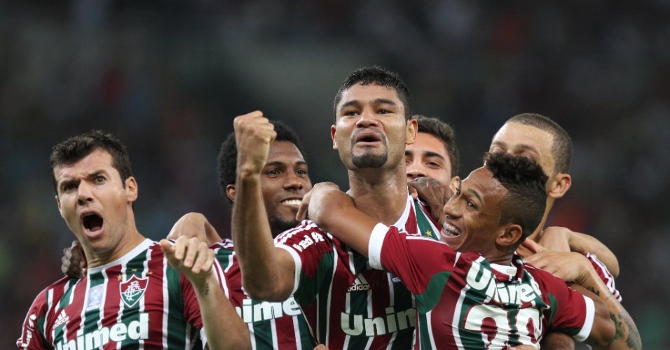 21.set.2013 - Gum, zagueiro do Fluminense, é abraçado pelos companheiros na comemoração do seu gol na partida contra o Coritiba