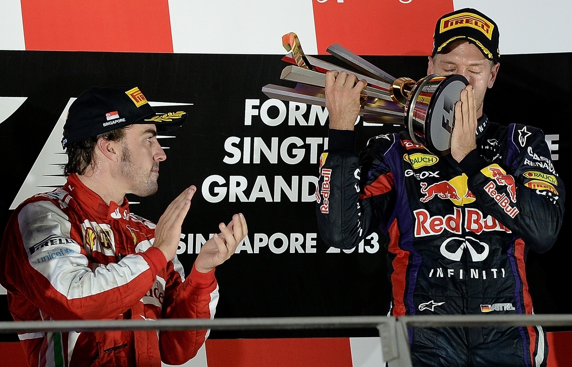 22.09.2013 - Alonso observa Vettel erguer troféu de mais uma vitória - MANAN VATSYAYANA / AFP