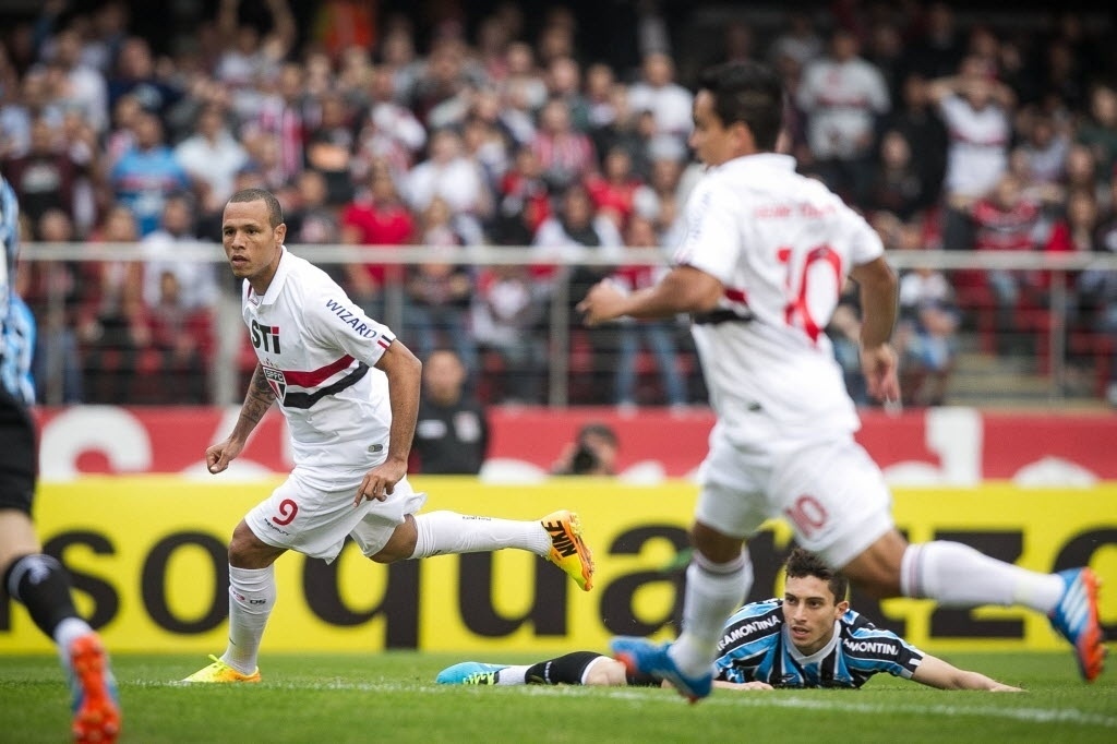 29.set.2013 - Luis Fabiano, acompanhado por Jadson, tenta jogada em partida contra o Grêmio no Campeonato Brasileiro - Rodrigo Capote / UOL