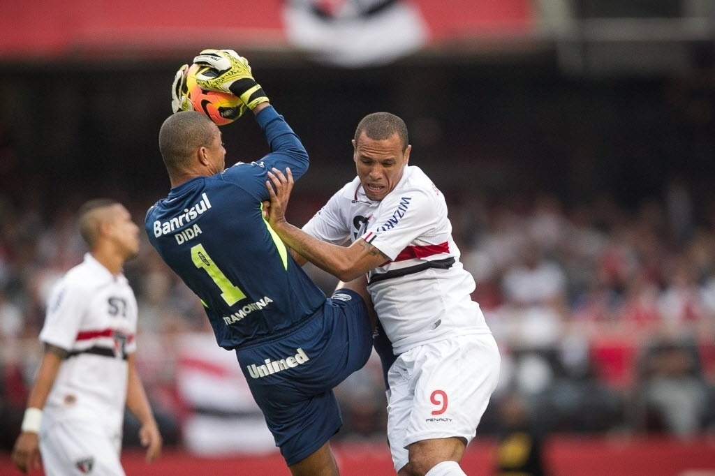 29.set.2013 - Luis Fabiano, do São Paulo, disputa a bola no alto com o goleiro Dida, do Grêmio, que fica com ela - Rodrigo Capote / UOL