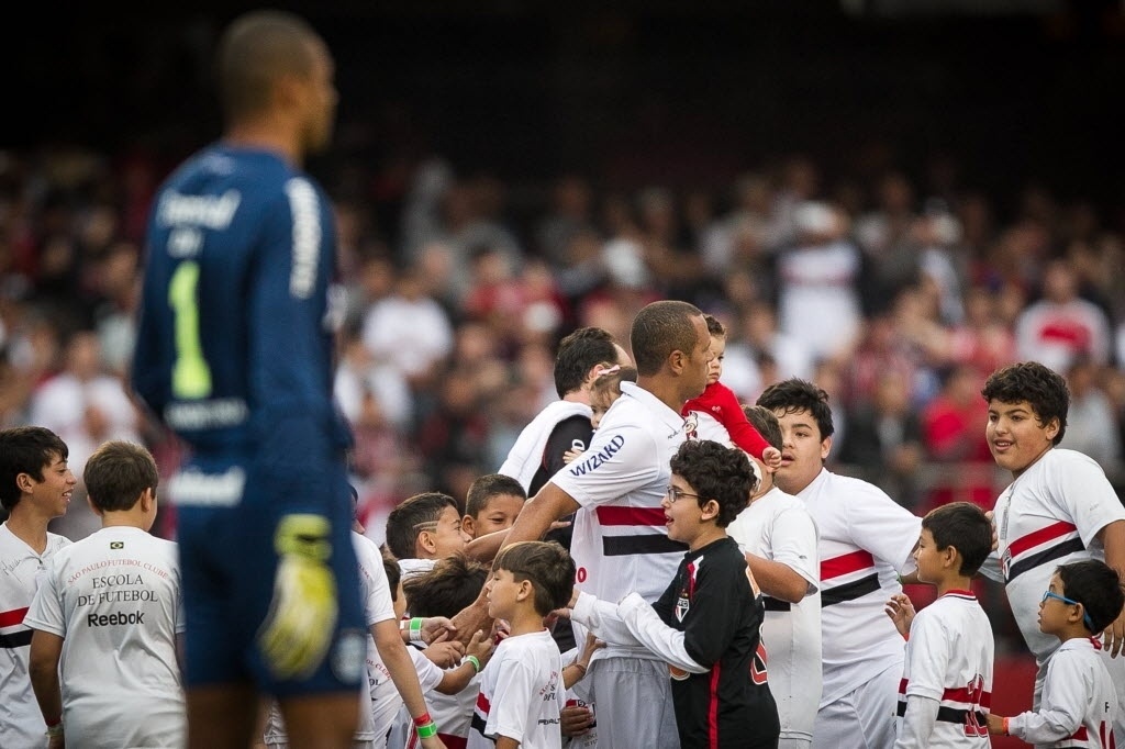 29.set.2013 - Luis Fabiano e Rogério Ceni, atletas do São Paulo, entram em campo cercados por um grupo de crianças para enfrentar o Grêmio - Rodrigo Capote / UOL
