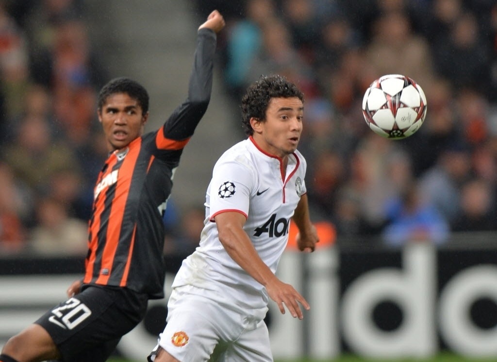 02.out.2013 - Brasileiros, Rafael (dir.), do Manchester United, e Douglas Costa, do Shakhtar, disputam a bola durante partida da Liga dos Campeões - AFP PHOTO/ SERGEI SUPINSKY
