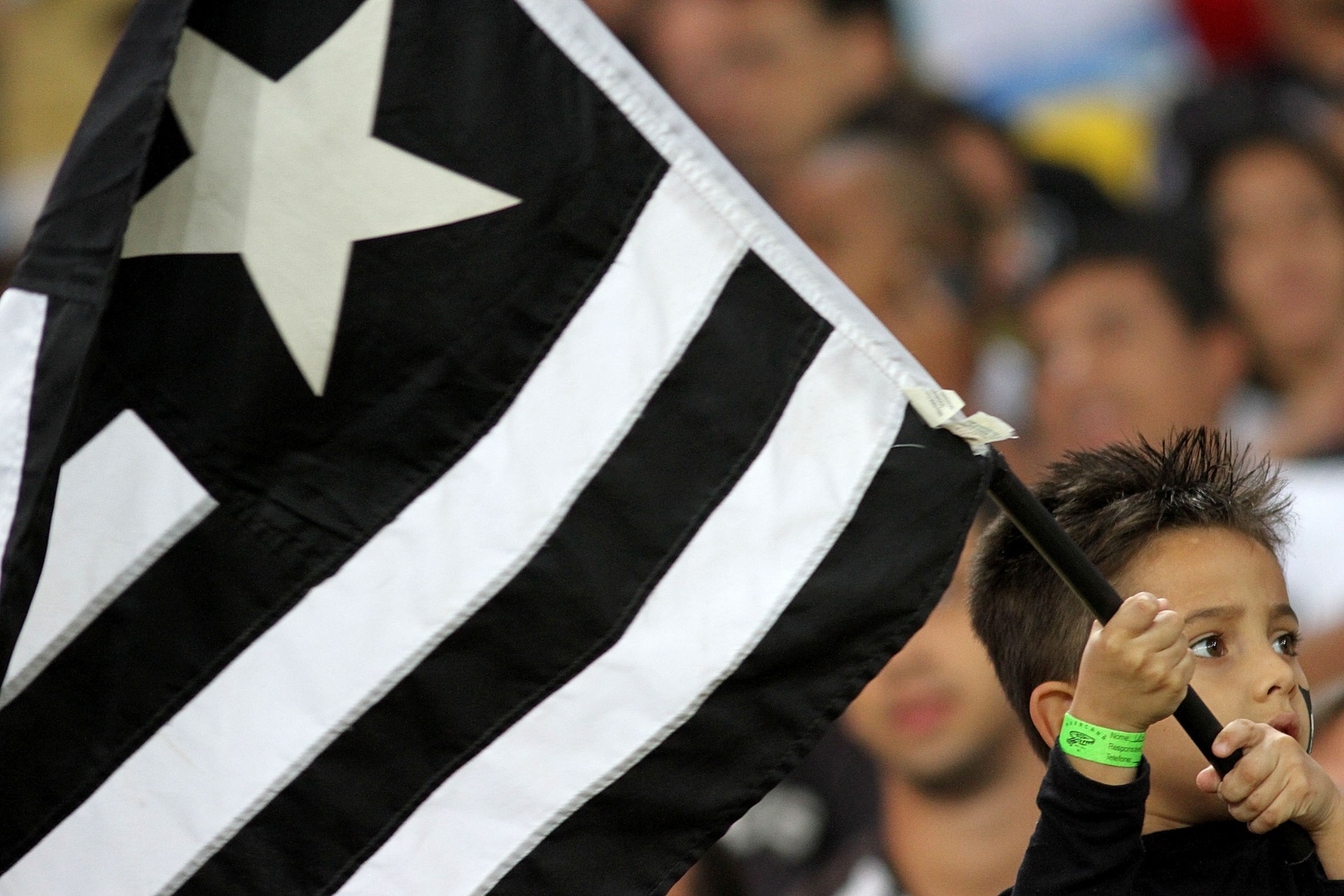 05.out.2013 - Com a bandeira do Botafogo, jovem torcedor aguarda o início do jogo contra o Grêmio, no Maracanã - Vitor Silva/SSPress