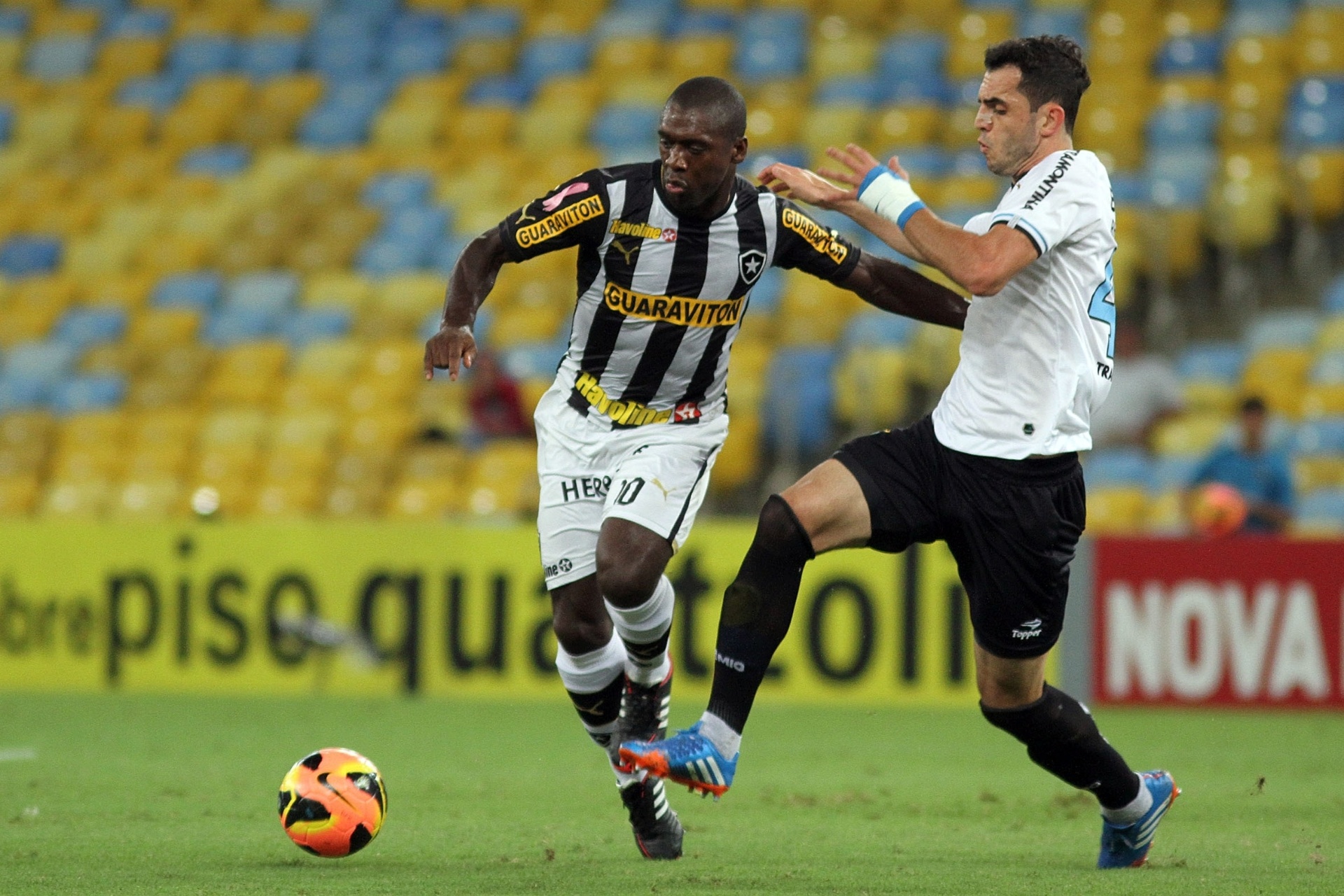 05.out.2013 - Zagueiro Rodolpho, do Grêmio, tenta tirar a bola de Seedorf, do Botafogo - Vitor Silva/SSPress