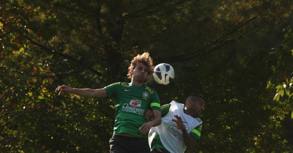 09.out.2013 - Henrique cabeceia bola ao lado de Daniel Alves em treino da seleção em Seul