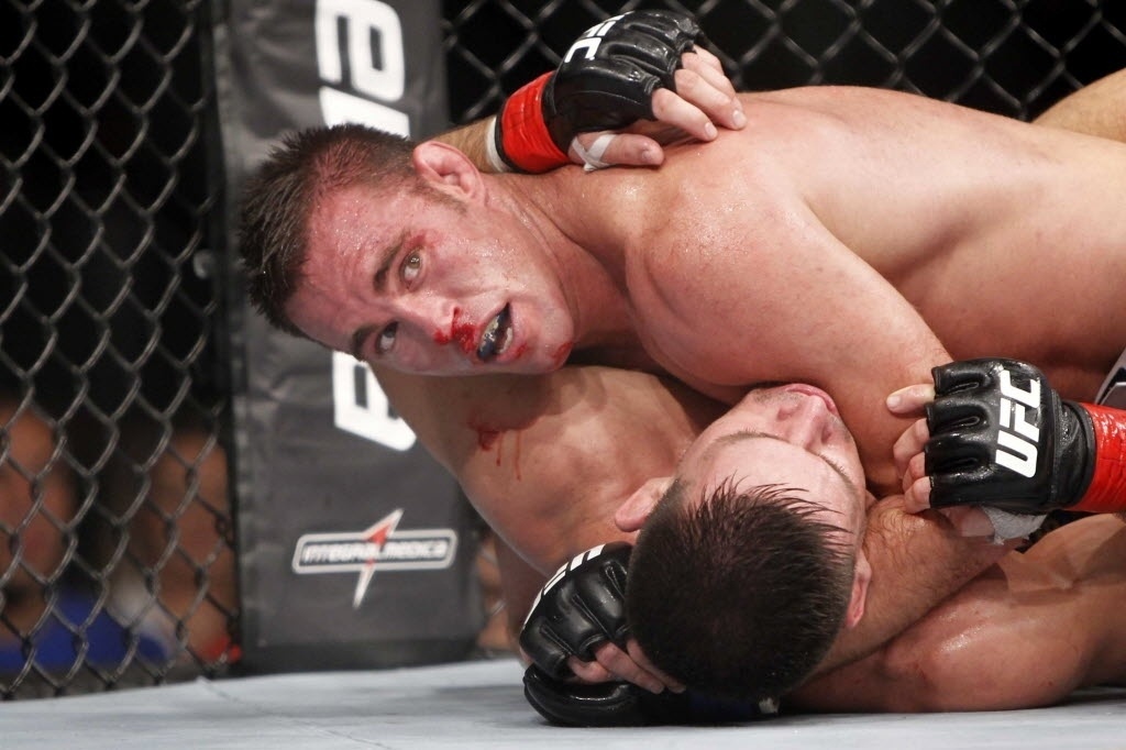 09.out.2013 - Demian Maia, de luvas com detalhes vermelhos, vai para o chão com Jake Shields durante a luta principal do UFC Barueri