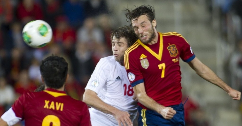 11.out.2013 - Michu (dir.), da Espanha, disputa a posse da bola com Verkhovtsov, de Belarus, em partida das Eliminatórias Europeias da Copa do Mundo