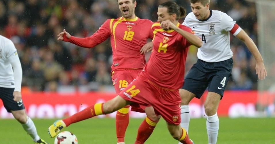 11.out.2013 - Steven Gerrard (dir.) disputa a bola com Dejan Damjanovic na partida entre Inglaterra e Montenegro pelas Eliminatórias Europeias