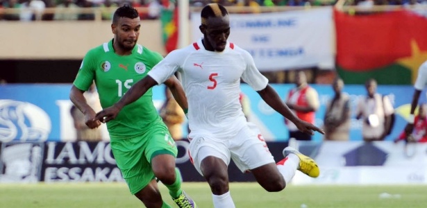Mohamed Koffi (d), de Burkina Fasso, tenta jogada contra a Argélia
