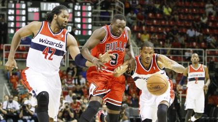 Trevor Ariza tenta proteger a bola de Luol Deng, do Chicago Bulls, enquanto o brasileiro Nenê observa em jogo da NBA no Brasil Trevor Ariza tenta proteger a bola de Luol Deng, do Chicago Bulls, enquanto o brasileiro Nenê observa em jogo da NBA no Brasil