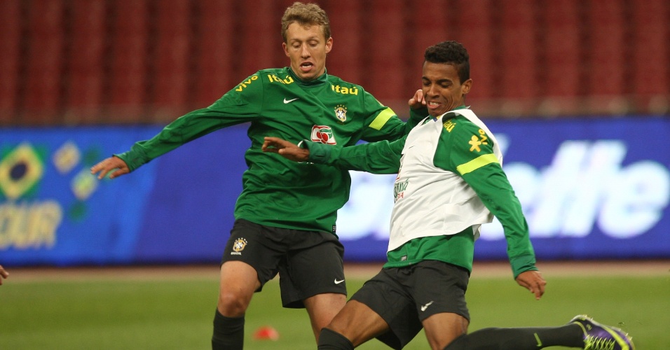 14.out.2013 - Lucas Leiva e Luiz Gustavo disputam bola em treino da seleção em Pequim