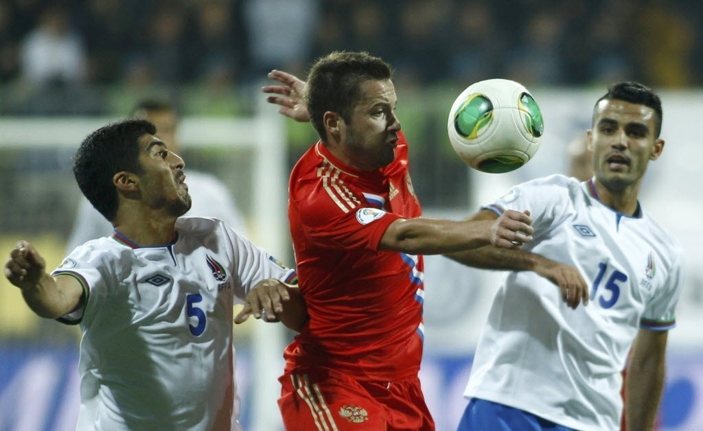 15.out.2013 - Elnur Allahverdiyev e Ruslan Abishov, do Azerbaijão, disputam pela bola com Viktor Fayzulin, da Rússia, em jogo das Eliminatórias Europeias