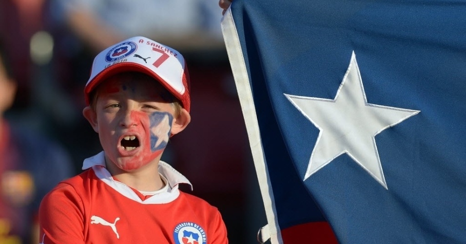 15.out.2013 - Garotinho chileno pinta o rosto com as cores da bandeira do seu país para assistir à partida contra o Equador