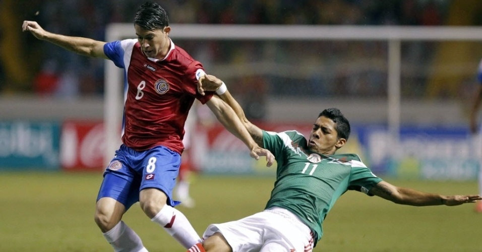15.out.2013 - Javier Aquino (dir.) tenta tirar a bola de Bryan Oviedo durante partida das Eliminatórias da Copa do Mundo entre México e Costa Rica