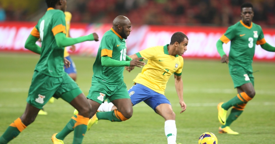 15.out.2013 - Lucas tenta arrancada contra defensores da Zâmbia no amistoso disputado em Pequim