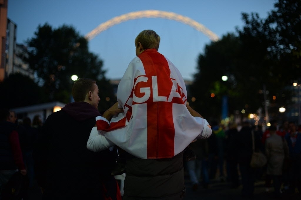 15.out.2013 - Nos ombros do pai, jovem torcedor da Inglaterra vai ao estádio de Wembley para assistir ao jogo entre Inglaterra e Polônia, que vale vaga direta na Copa do Mundo