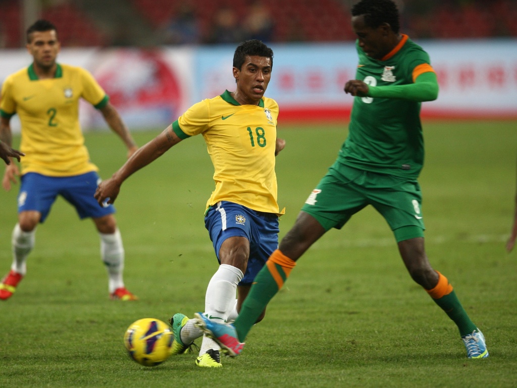 15.out.2013 - Paulinho tenta passe durante o confronto do Brasil contra a Zâmbia em Pequim