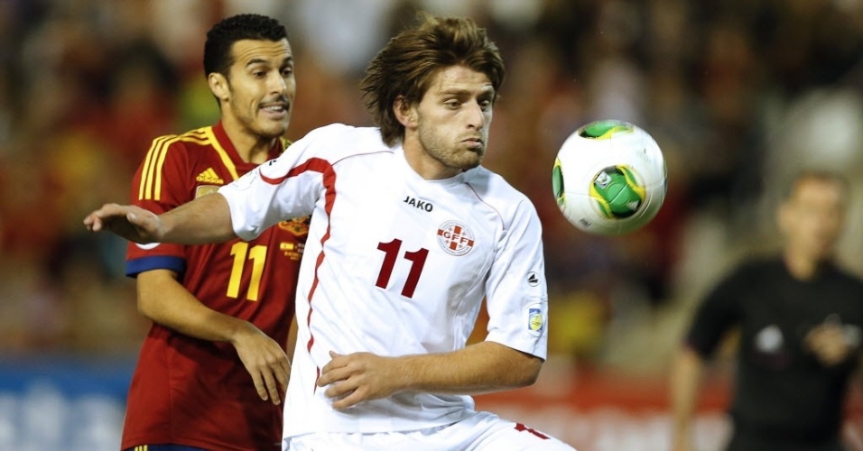 Pedro (esq.), atacante da Espanha, disputa a bola com Grigalashvili, da Geórgia, em partida das eliminatórias da Copa-2014; espanhois venceram por 2 a 0