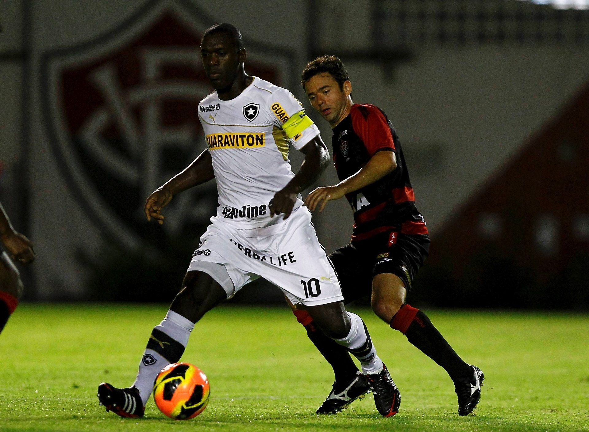 17.out.2013 - Clarence Seedorf, do Botafogo, encara a marcação de Juan, lateral do Vitória, durante jogo pelo Brasileiro - EDUARDO MARTINS/AGÊNCIA A TARDE/ESTADÃO CONTEÚDO