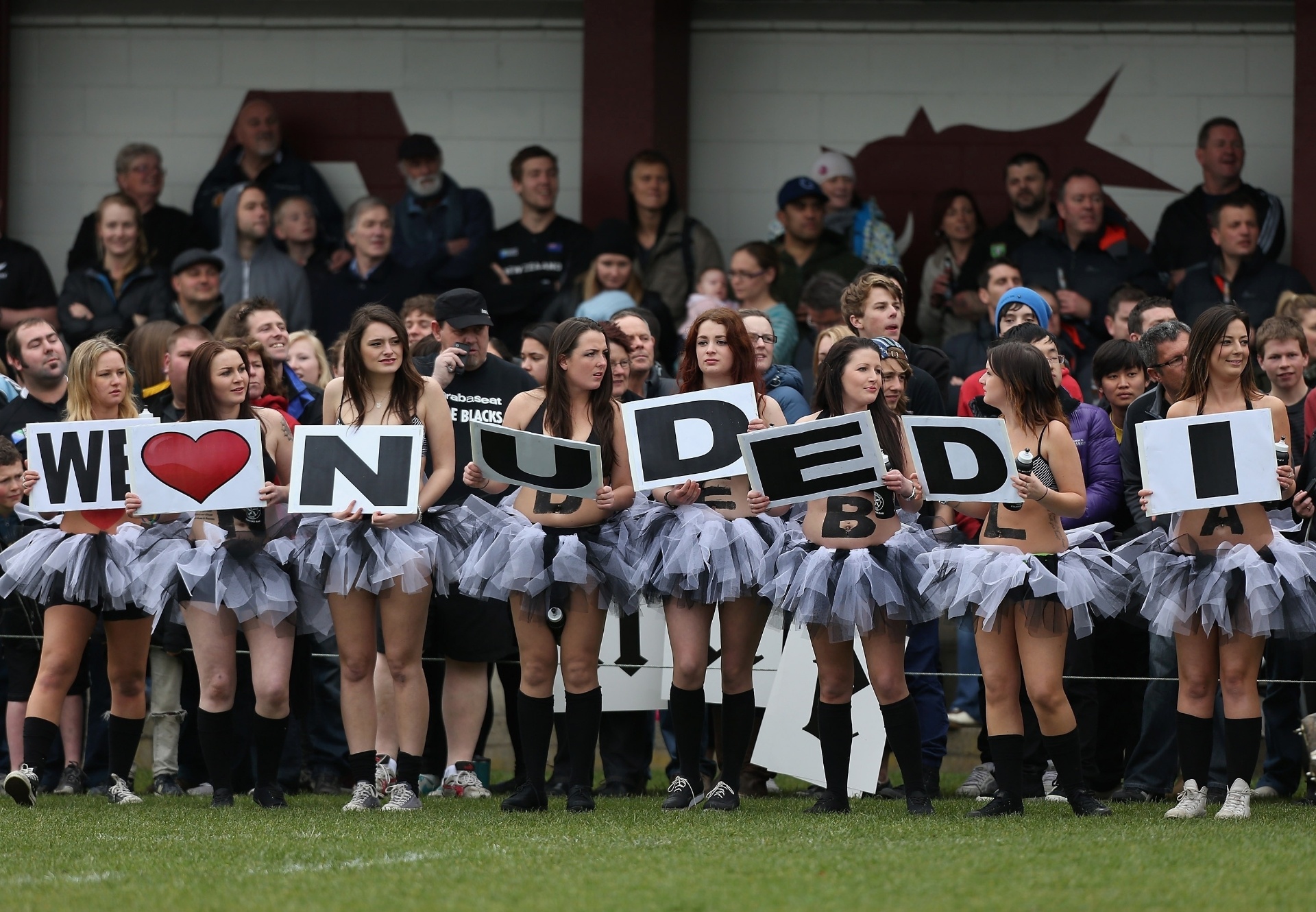 Cheerleaders carregam placas no campeonato rúgbi para peladões - Sandra Mu/Getty Images