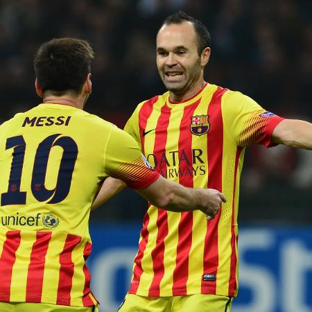 22.out.2013 - Messi recebe abraço de Iniesta após marcar o gol de empate do Barcelona no jogo contra o Milan - AFP PHOTO / GIUSEPPE CACACE