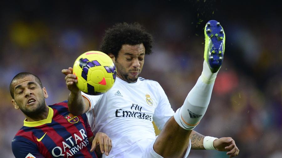 26.out.2013 - Os laterais Daniel Alves e Marcelo disputam bola durante clássico vencido pelo Barcelona por 2 a 1 - Javier Soriano/AFP