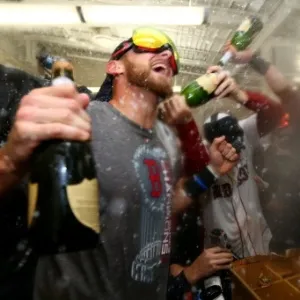 30.out.2013 - Jogadores do Boston Red Sox celebram mascarados e com champanhe a conquista da MLB, a liga de beisebol dos EUA; foi o 1° título da franquia em casa desde 1918 - Elsa/Getty Images/AFP