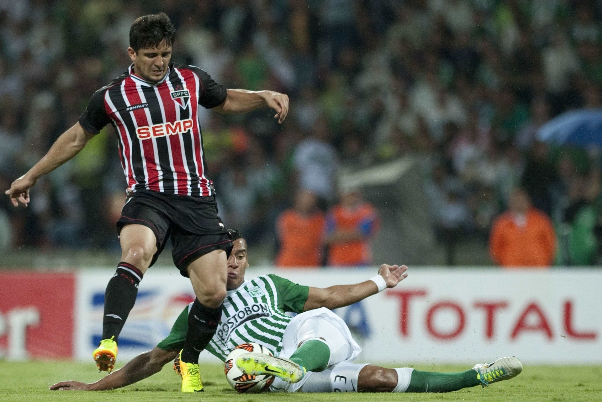 06.nov.2013 - Aloísio, atacante do São Paulo, divide a bola com jogador do Atlético Nacional - AFP PHOTO/Raul ARBOLEDA