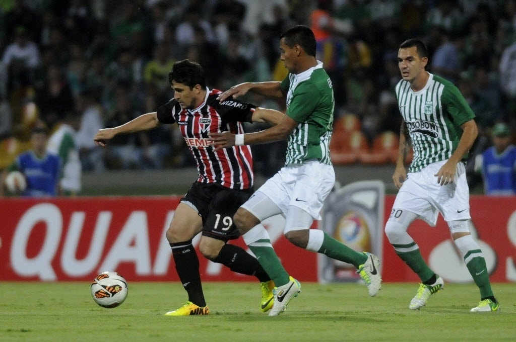 06.nov.2013 - Aloísio, do São Paulo, é puxado por Diego Peralta, do Atlético Nacional, durante jogo da Sul-Americana - EFE/LUIS EDUARDO NORIEGA