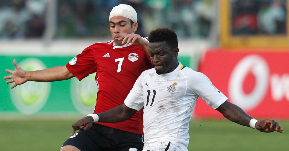 15.out.2013 - Sulley Muntari (d), de Gana, disputa jogada com Ahmed Fathy, do Egito, durante partida das eliminatórias da Copa-2014; ganenses golearam por 6 a 1