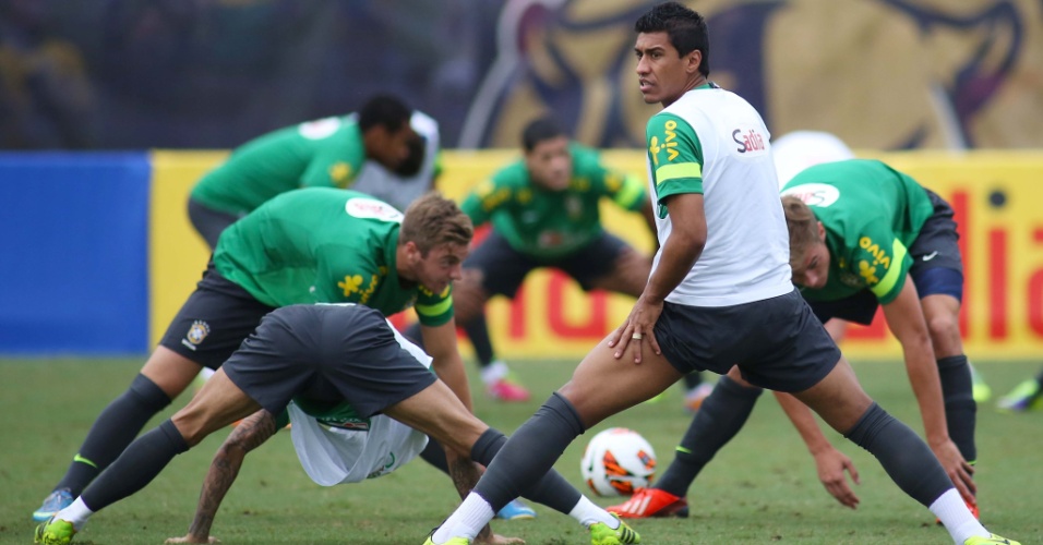 13.nov.2013 - Paulinho faz alongamento durante treino da seleção brasileira