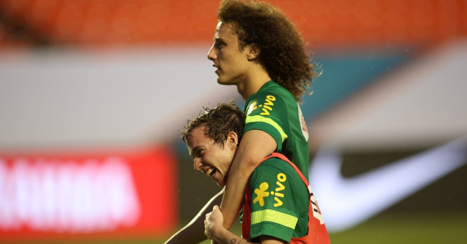 15.nov.2013 - Confirmado como titular contra Honduras, Bernard é abraçado por David Luiz durante treino