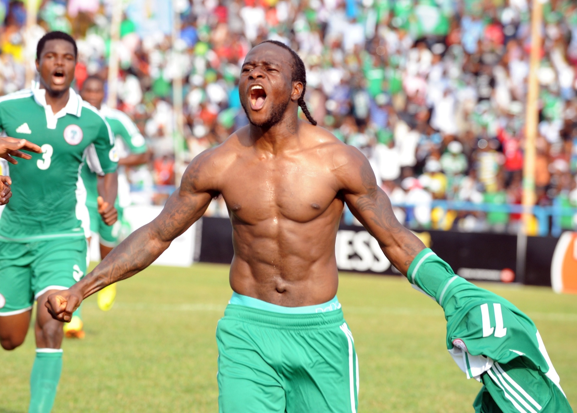 16.nov.2013 - O nigeriano Moses marca gol de pênalti, tira camisa para comemorar e toma um cartão amarelo durante a partida contra a Etiópia - AFP PHOTO/PIUS UTOMI EKPEI