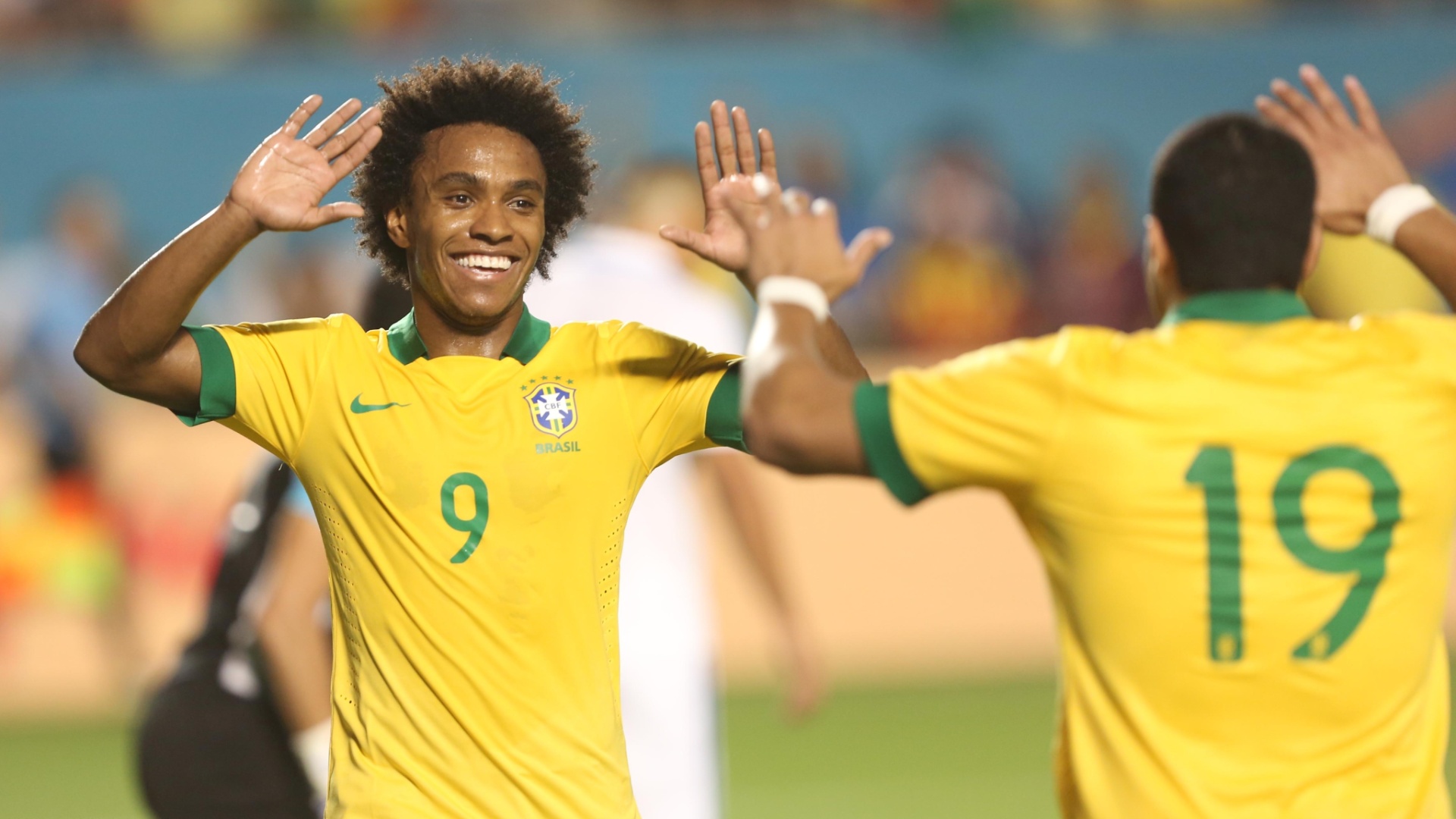 16.nov.2013 - Autores do quarto e quinto gols do Brasil, Willian (e) e Hulk comemoram no amistoso contra Honduras em Miami