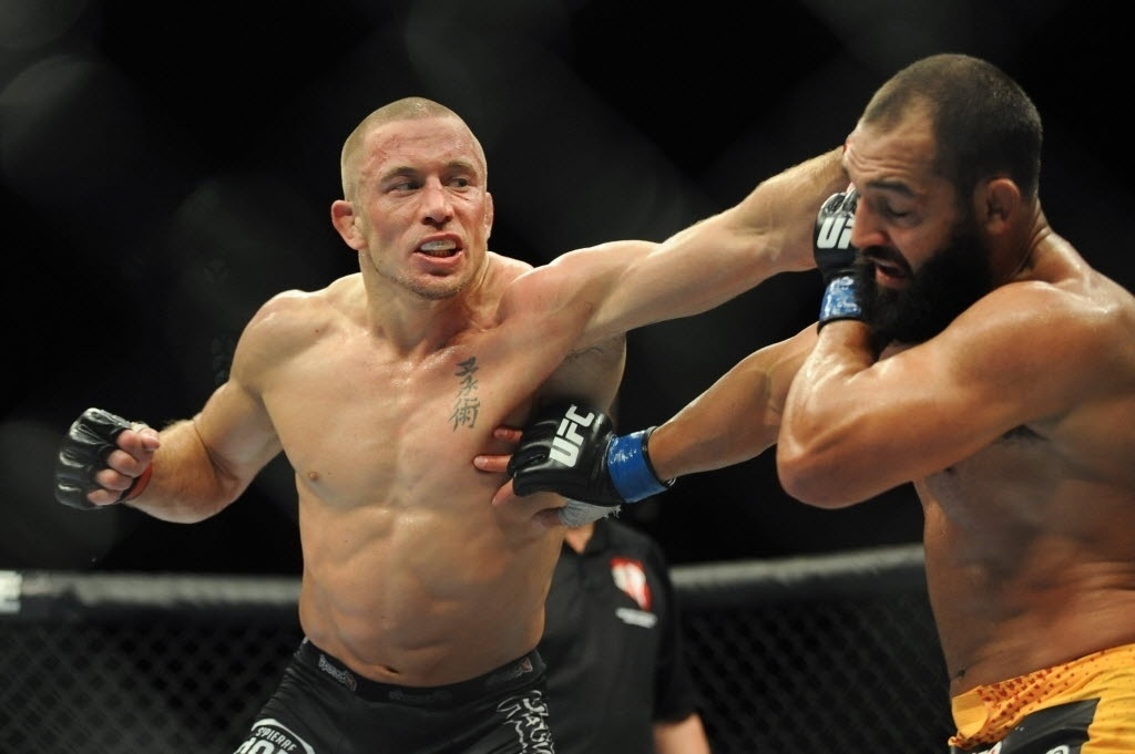 17.nov.2013 - Georges St-Pierre (esq.) acerta o americano Johny Hendricks durante luta do UFC 167; o canadense venceu por decisão dividida dos juízes e manteve o cinturão dos meio-médios - Stephen R. Sylvanie-USA TODAY