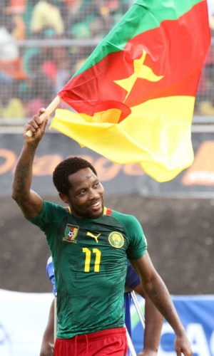 17.nov.2013  - Jean Makoun carrega uma bandeira de Camarões pelo campo após vitória do time nas Eliminatórias Africanas