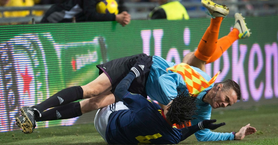 19.nov.2013 - Bandeirinha alemão Holger Henschel é derrubado após dividida entre jogadores de Holanda e Colômbia