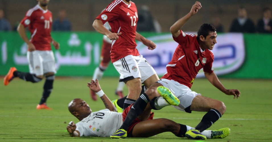 19.nov.2013 - Ayew, de Gana, dá carrinho para tirar a bola de Rabia, do Egito; apesar da derrota por 2 a 1, ganenses se classificaram para a Copa-2014