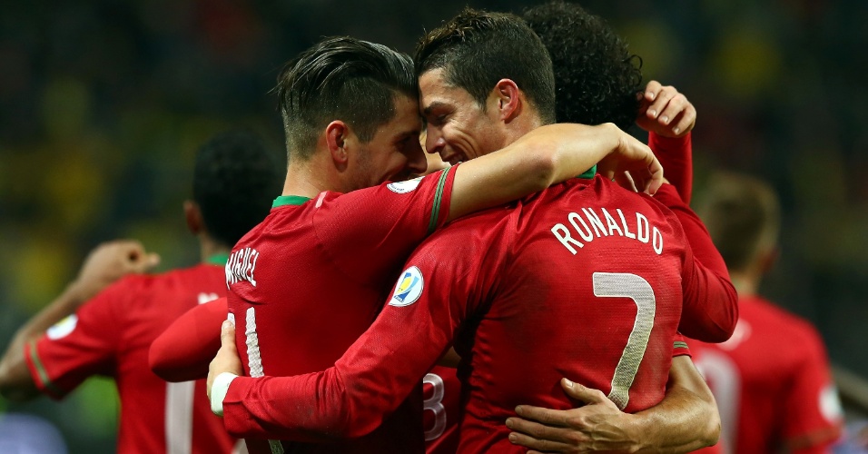 19.nov.2013 - Cristiano Ronaldo abraça o companheiro Miguel Veloso após marcar para Portugal na partida contra a Suécia; vitória por 3 a 2 classificou os portugueses para a Copa-2014