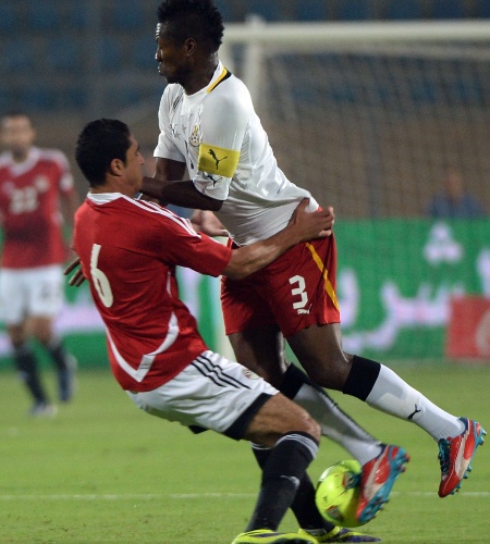 19.nov.2013 - Rabia (à esquerda), do Egito, disputa bola com Asamoah Gyan, de Gana; mesmo com a derrota por 2 a 1, ganenses se classificaram para a Copa-2014