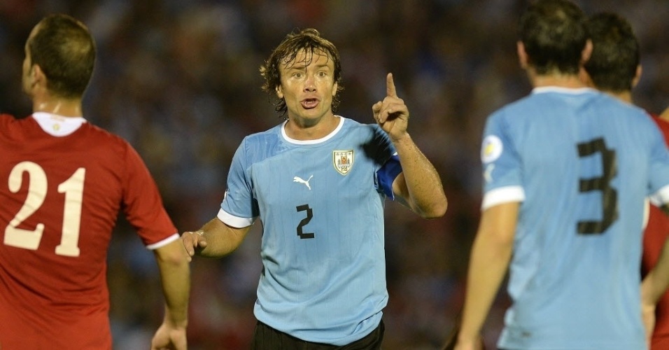 20.nov.2013 - Lugano conversa com o zagueiro Gódin no empate do Uruguai com a Jordânia por 0 a 0