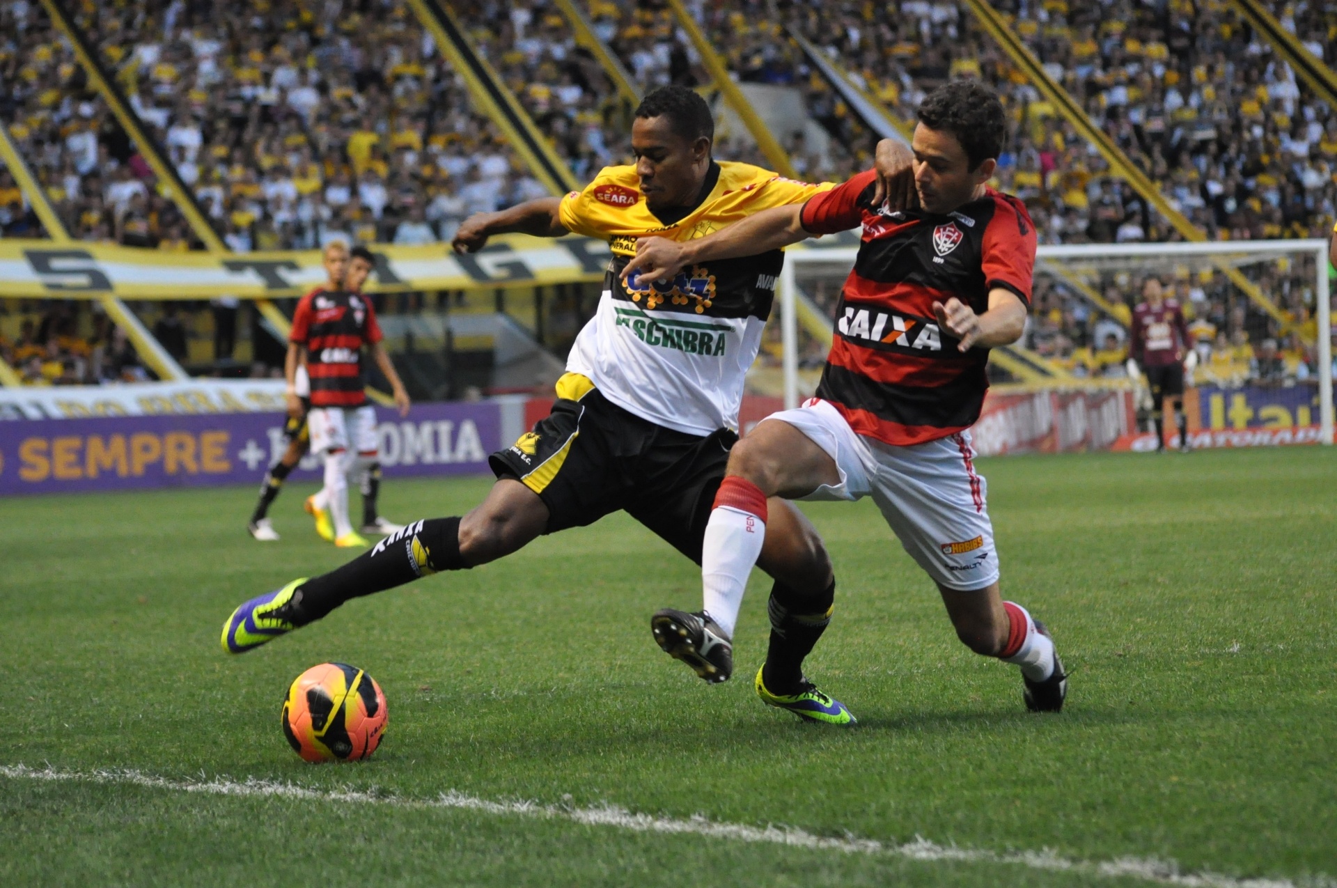 Lins, atacante do Criciúma, e Juan, lateral do Vitória, disputam a bola próxima à linha lateral (23.nov.13) - DEZA BERGMANN/ESTADÃO CONTEÚDO