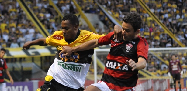 Lins, atacante do Criciúma, e Juan, lateral do Vitória, disputam a bola próxima à linha lateral - DEZA BERGMANN/ESTADÃO CONTEÚDO