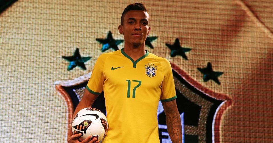 Volante Luiz Gustavo exibe a camisa a ser usada pela seleção brasileira na Copa do Mundo de 2014 (24.nov.2013)