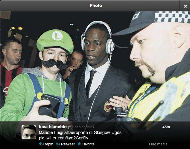 25.nov.2013 - Mario Balotelli é recebido em aeroporto na Escócia por torcedor fantasiado de Luigi