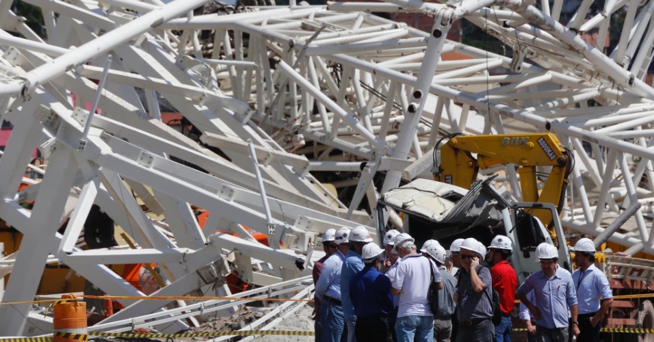 Homens da Defesa Civil e funcionários da construtora próximos aos escombros do estádio Itaquerão um dia apos o acidente que matou dois operários