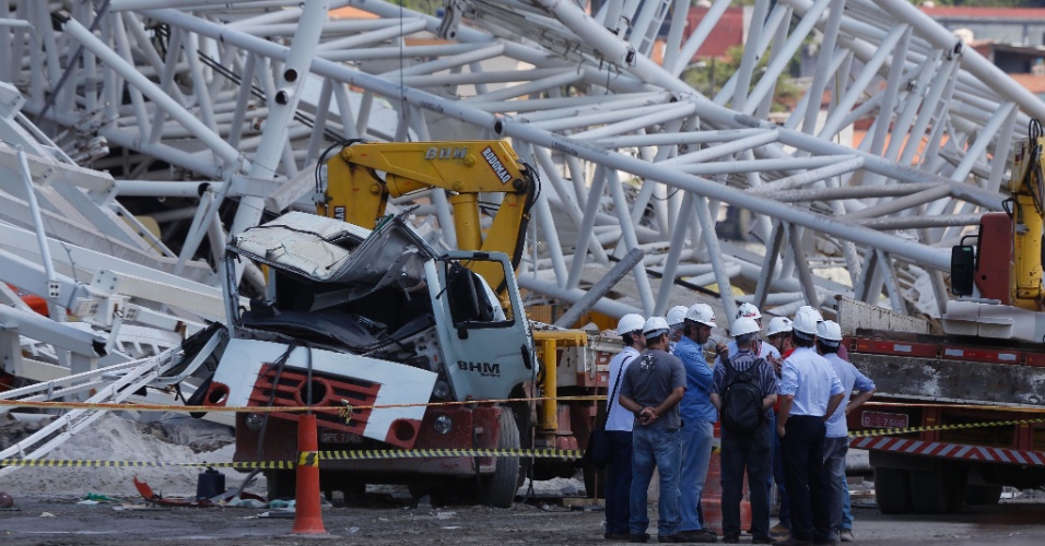 Homens da Defesa Civil e funcionários da construtora próximos aos escombros do estádio Itaquerão um dia apos o acidente que matou dois operários