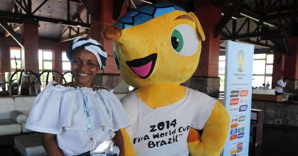 03.dez.2013 - Mulher vestida com trajes típicos da Bahia posa ao lado do mascote Fuleco em evento em comemoração à semana do sorteio da Copa do Mundo