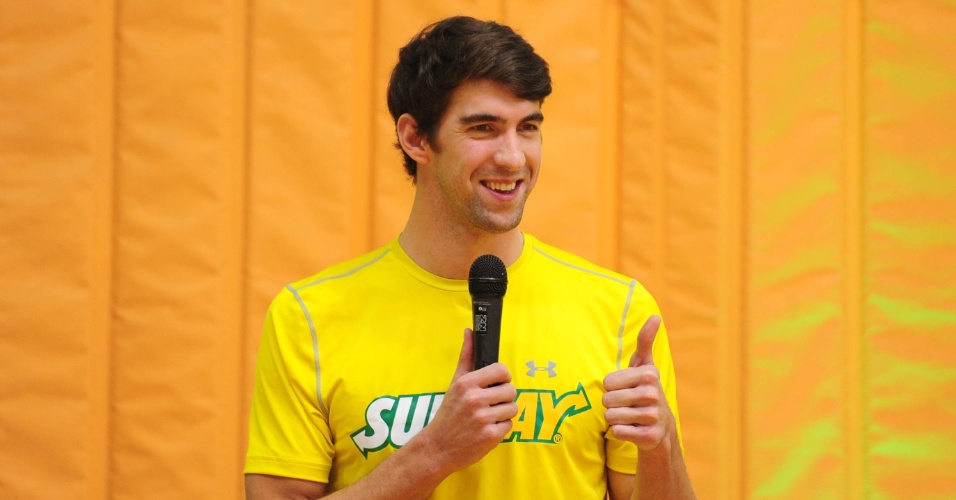 Ex-nadador Michael Phelps acena durante evento com crianças em São Paulo